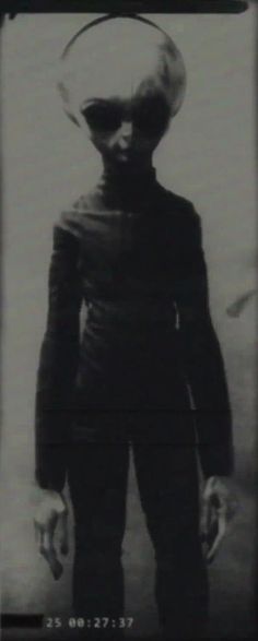 an alien is standing in front of a black and white photo