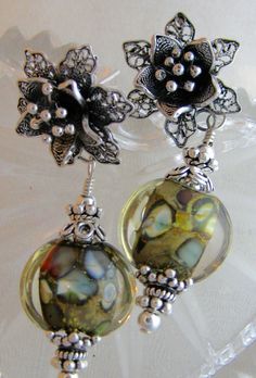 "Sterling silver flower posts; lampwork glass beads; sterling silver components.  Silver flower is 3/4\" x 3/4\".  Entire earring is 2\" in length. Glass beads are 1/2\" wide." Lampwork Bead Earrings, Beads Earrings, Pattern Glass, Sterling Silver Flowers, Lampwork Glass Beads, Earrings Sterling Silver, Silver Flowers, Green And Blue, Lampwork Beads