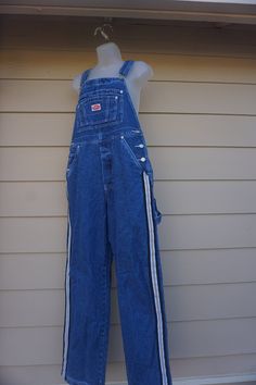 "Vintage denim overalls made by Revolt. Labeled as a size Large. In great vintage condition. Measurements taken across front laid flat 17'\" across front of waist 22\" across front of hips 12.5\" rise 30\" inseam" 90s Style Blue Denim Overalls, 90s Denim Overall Jumpsuit, 90s Style Denim Overall Jumpsuit, Retro Denim Bib Front Jumpsuit, Retro Denim Jumpsuit With Bib Front, Denim Blue Retro Overalls, Retro Denim Blue Overalls, Vintage Denim Overalls In Medium Wash, Vintage Medium Wash Denim Overalls