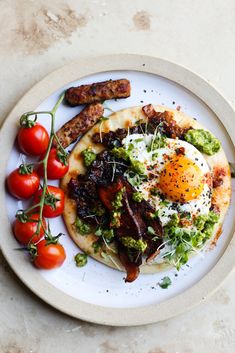 an omelet with bacon, eggs and tomatoes on a plate