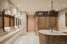 a bathroom with two sinks and mirrors on the wall next to each other in it