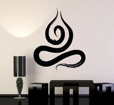 a dining room table with black chairs and a wall decal that has the shape of a snake on it