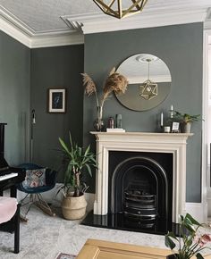 a living room filled with furniture and a fire place next to a mirror on the wall