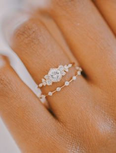 a woman's hand with a diamond ring on it