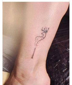 a woman's foot with a small tattoo on her left ankle and a wand in the middle