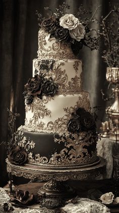 a three tiered wedding cake with black and white flowers on the top, sitting on a table