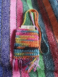 a multicolored purse sitting on top of a colorful blanket