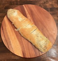 a loaf of bread sitting on top of a wooden cutting board