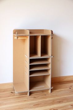 an empty cardboard closet is shown on the floor in front of a white wall and wooden floors