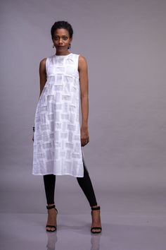 White organic cotton sleeveless woman's top with crew neck, side slits and textured front. We can make the texture All round instead of only the front. Do DM us for more information to customise. Geometric folds are created on fabric using the shadow folding technique, which is made from a single three step process. Every Fold adds a unique intricacy, and gives it a dimensionality which is not present on a flat surface, thus creating a breathtaking piece of textile art. This garment is inspired Spring Sleeveless Tunic, Summer Cotton Straight Kurta Tunic, Summer Fitted Straight Kurta Tunic, Fitted Straight Kurta Tunic For Summer, Sleeveless Cotton Kurta For Summer, Fitted Sleeveless Kurta For Spring, White Sleeveless Cotton Kurta, Spring Fitted Sleeveless Kurta, Sleeveless White Kurta For Spring