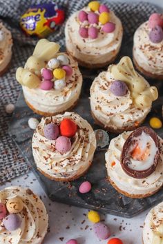 some cupcakes are decorated with candy and candies on a tray next to an easter egg