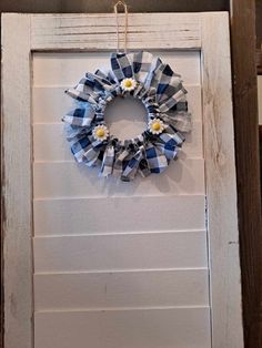 a blue and white wreath hanging on the side of a door