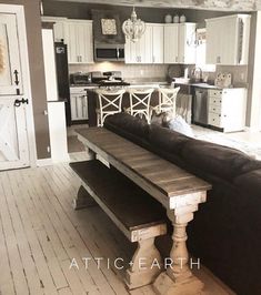 a living room and kitchen are shown in this old time house style home with white painted wood flooring