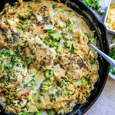 a skillet filled with broccoli and chicken covered in grated parmesan cheese