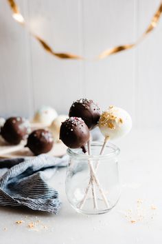 chocolate covered marshmallows in a glass jar with gold sprinkles