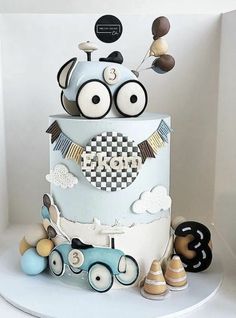 a three tiered cake decorated with an image of a car and some other decorations