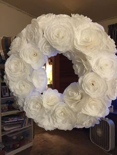 a white wreath made out of paper flowers