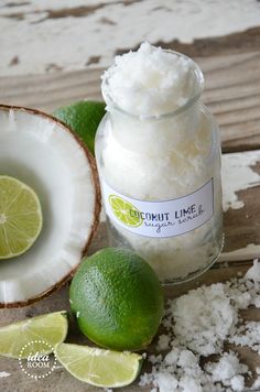 limes and coconut on a wooden table next to a jar of coconut lime scrub