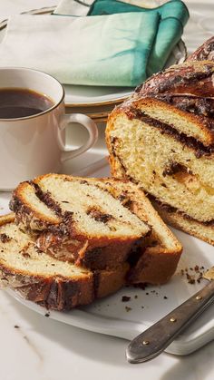 sliced loaf of bread on plate next to cup of coffee