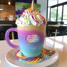 there is a cup with whipped cream and a unicorn horn on it