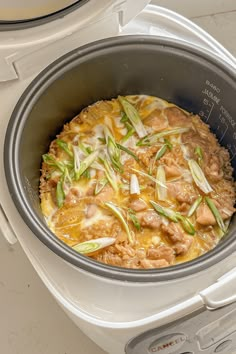 an open crock pot filled with meat and vegetables