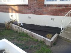 an empty bed in front of a brick building