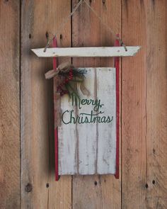 a merry christmas sign hanging on the side of a wooden wall