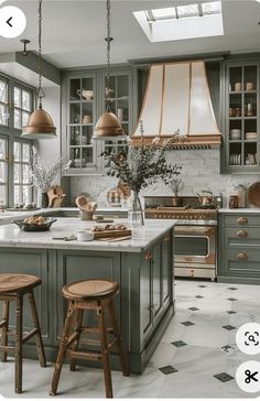 a kitchen with two stools in front of the island and an oven above it