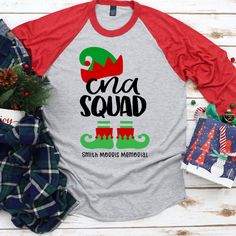 Bring some holiday cheer to all your patients with our super cute CNA Squad Christmas shirt! This adorable elf shirt can be personalized too. Add your unit, or the name of the facility where you work. These shirts are perfect for wearing to work during the holiday season to spread a little cheer. This shirt also looks great at all those Christmas gatherings and makes the perfect shirt for office Christmas photos! Our 3/4 sleeve raglan is unisex sizing and runs true to size. Please be sure to dou Cna Shirts, Graduation Shirts For Family, Baseball First Birthday, Baseball Team Shirt, Cna Nurse, Elf Shirt, Number Shirt, 1st Birthday Shirts, Nurse Christmas