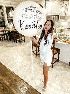 a woman holding a balloon that says future mr and mrs koonty on it