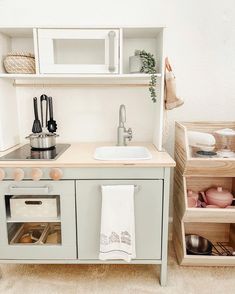 a small kitchen with an oven, sink and shelves