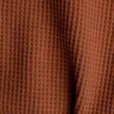 the back of a woman's brown sweater, showing her chest and shoulder area