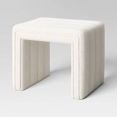 a small white stool sitting on top of a table