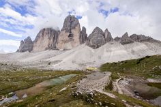 the mountains are covered in snow and green grass, with small lakes surrounded by rocks