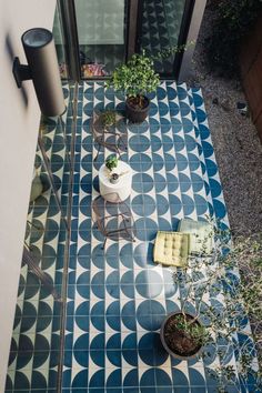 an aerial view of a tiled patio with potted plants on the floor and in front