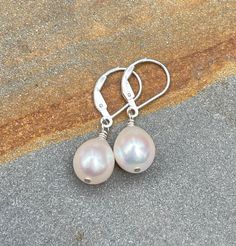 White Pearl Earrings, Sterling Silver Leverback Earrings. Dainty Dangle & Drop Earrings. June Birthstone.  The earrings are handmade using freshwater pearls and sterling silver components. The pearls are ivory white in color with great luster and subtle overtones of pink, they are teardrop shaped, and measure ~8.3 mm wide. As creations of nature, the pearls are not perfectly identical but very similar in size and shape. You have a choice of earring wires between simple lever back or French hook. The earrings are perfect for summer or really any time of the year, they measure ~1 1/16 to 1 3/16 inch (2.7 to 3 cm) long depending on earring wires. You may receive a remake of these classic white freshwater teardrop pearl sterling silver earrings made with pearls from the same lot. Pictures are Adjustable Nickel-free Teardrop Pearl Earrings, Elegant Pearl Drop Jewelry For Birthday, Nickel-free Teardrop Pearl Earrings For Anniversary, Nickel Free Teardrop Pearl Earrings For Anniversary, Teardrop Pearl Earrings With Lever Back For Gift, Gift Pearl Drop Earrings With Lever Back, Elegant Silver Earrings For Birthday, White Sterling Silver Earrings For Birthday, Adjustable Teardrop Earrings For Anniversary