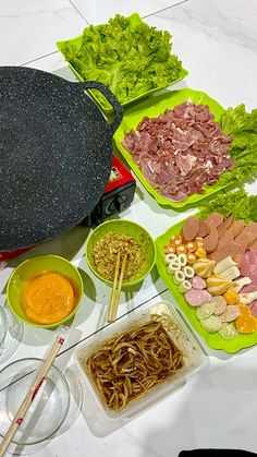 a table topped with bowls filled with food and chopsticks next to an oven mitt