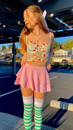 a woman in a pink skirt and green striped socks