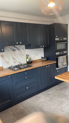 a kitchen with blue cabinets and marble counter tops is seen in this image from the front view