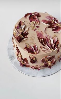 a cake with flowers on it sitting on top of a white countertop next to a knife