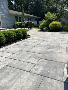 an outdoor patio with stone pavers and shrubbery