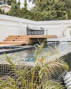 an outdoor pool surrounded by plants and chairs