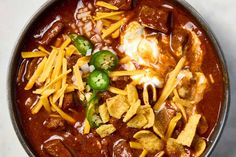 a bowl filled with chili cheese and tortilla chips