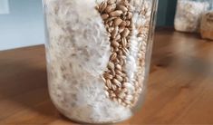 a glass jar filled with grains sitting on top of a wooden table