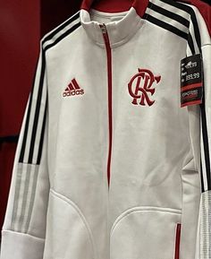 a white adidas jacket with red and black stripes