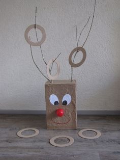 a paper bag with a face and two circles attached to it, sitting on the floor