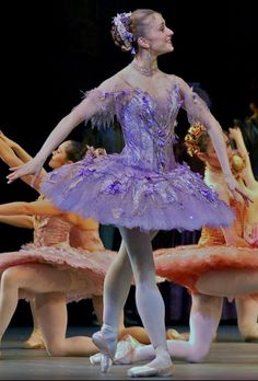 the ballerina is wearing a purple tutu