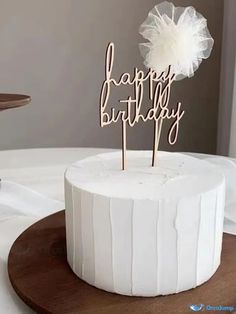 a white cake with a happy birthday sign on top and a flower in the middle