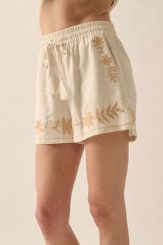 Linen-blend shorts. Floral embroidery. Elastic waist with tassel drawstring. Side pockets. Wide leg. Thigh length. Relaxed fit. 70% Rayon, 30% Linen. Imported. Designed in LA. Model wears size S. Cream Floral Embroidery Bottoms For Summer, Summer Floral Embroidery Cream Bottoms, Summer Cream Bottoms With Floral Embroidery, Bohemian Short Length Bottoms With Drawstring, Casual Embroidered Relaxed Fit Shorts, Casual Embroidered Shorts With Relaxed Fit, Casual Spring Shorts With Tassels, Casual Tassel Shorts For Spring, Casual Floral Embroidery Bottoms For Vacation