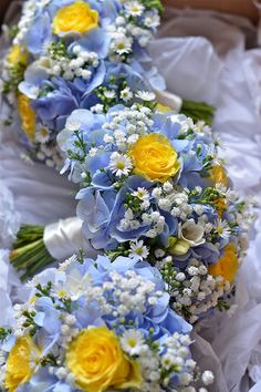 blue and yellow bridal bouquets are arranged in a row on top of each other